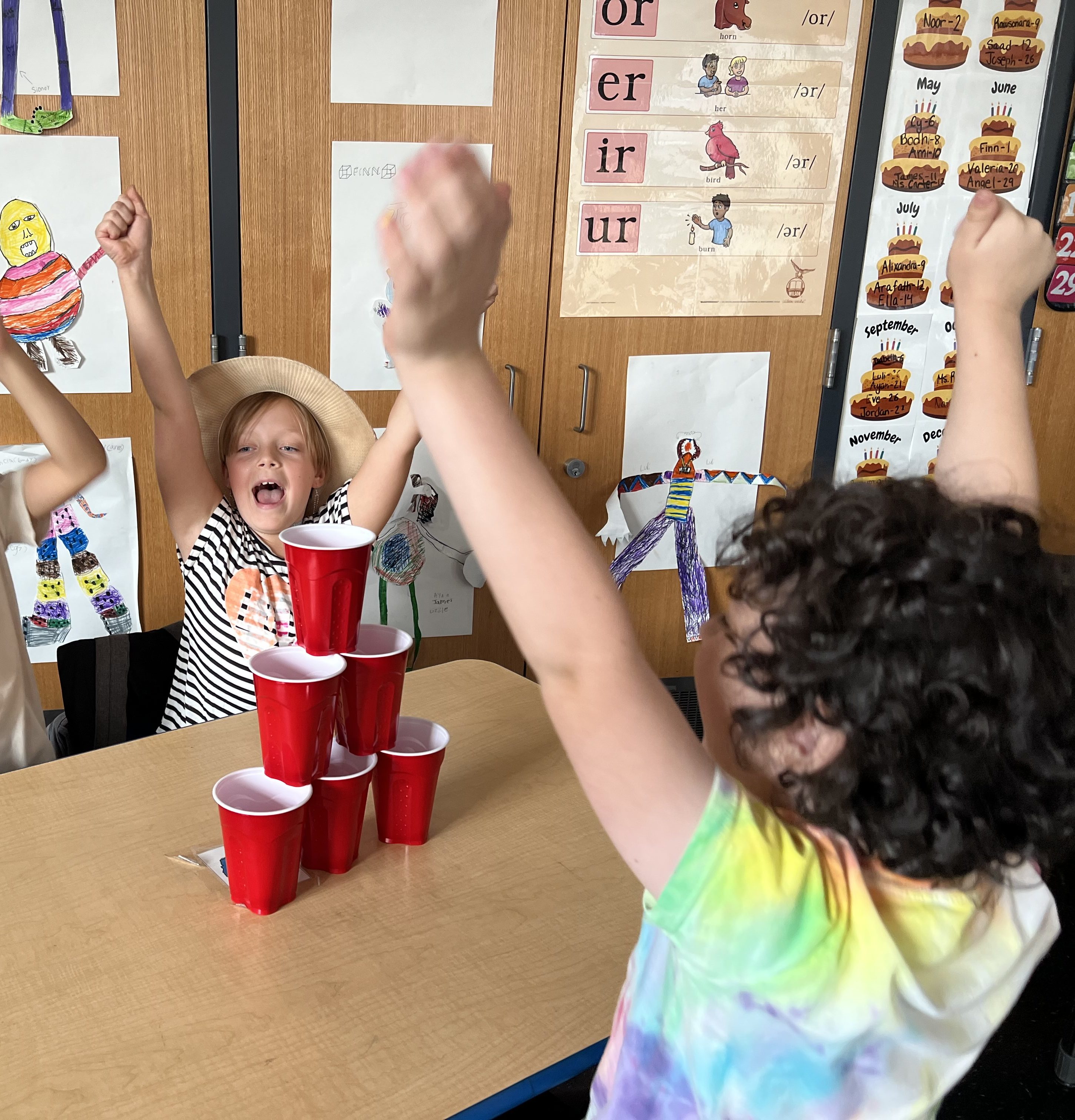 students happily stacked a red cup house